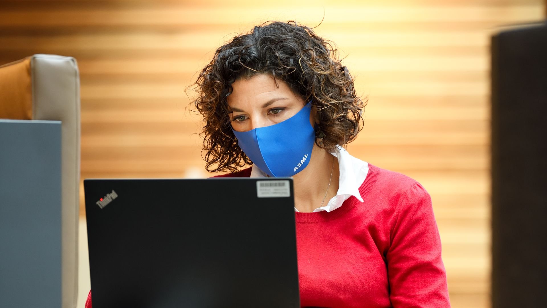 A woman in an ASML facemask works on her laptop A woman in an ASML facemask works on her laptop