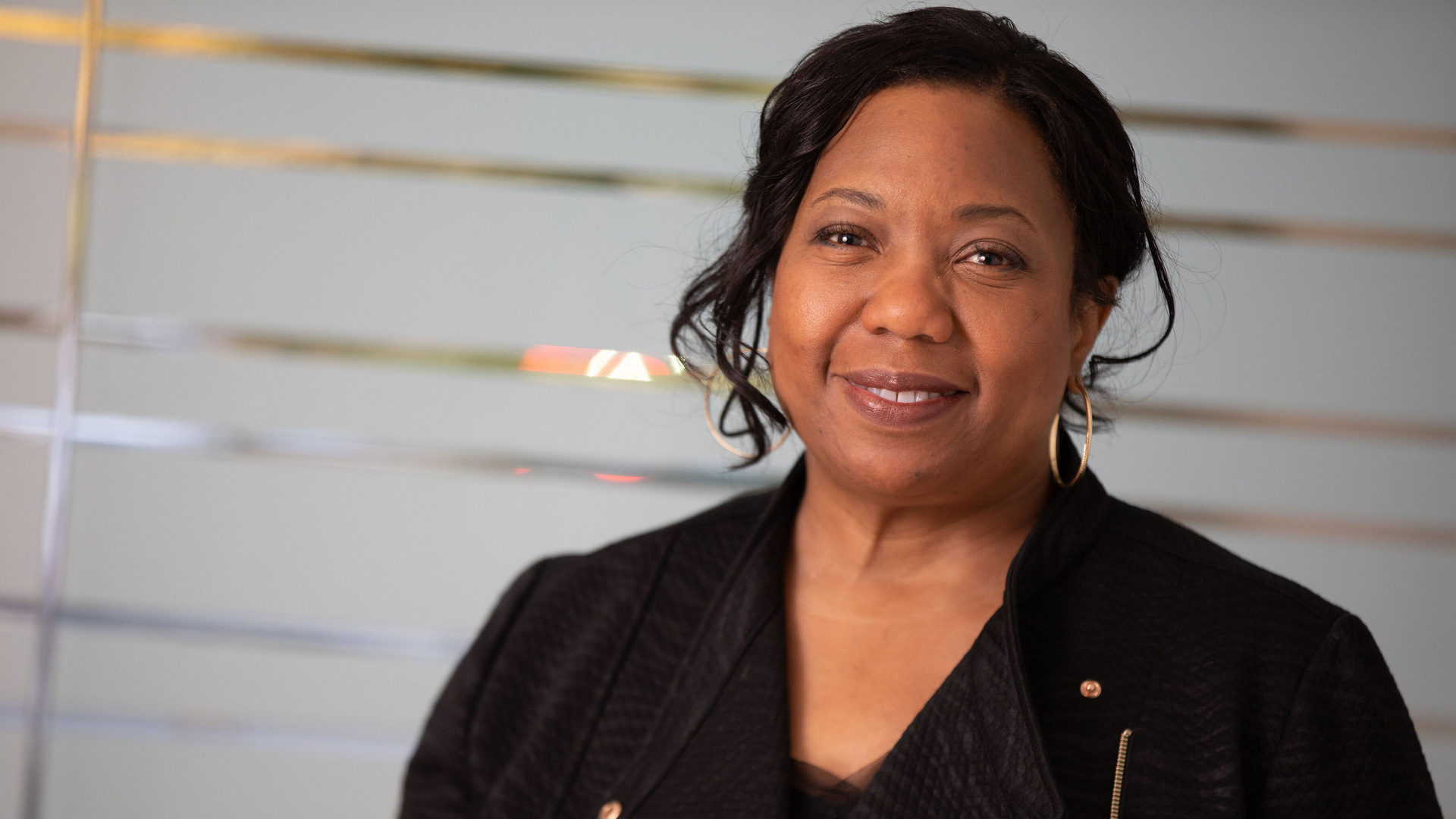 A woman in a black sweater smiles at the camera.