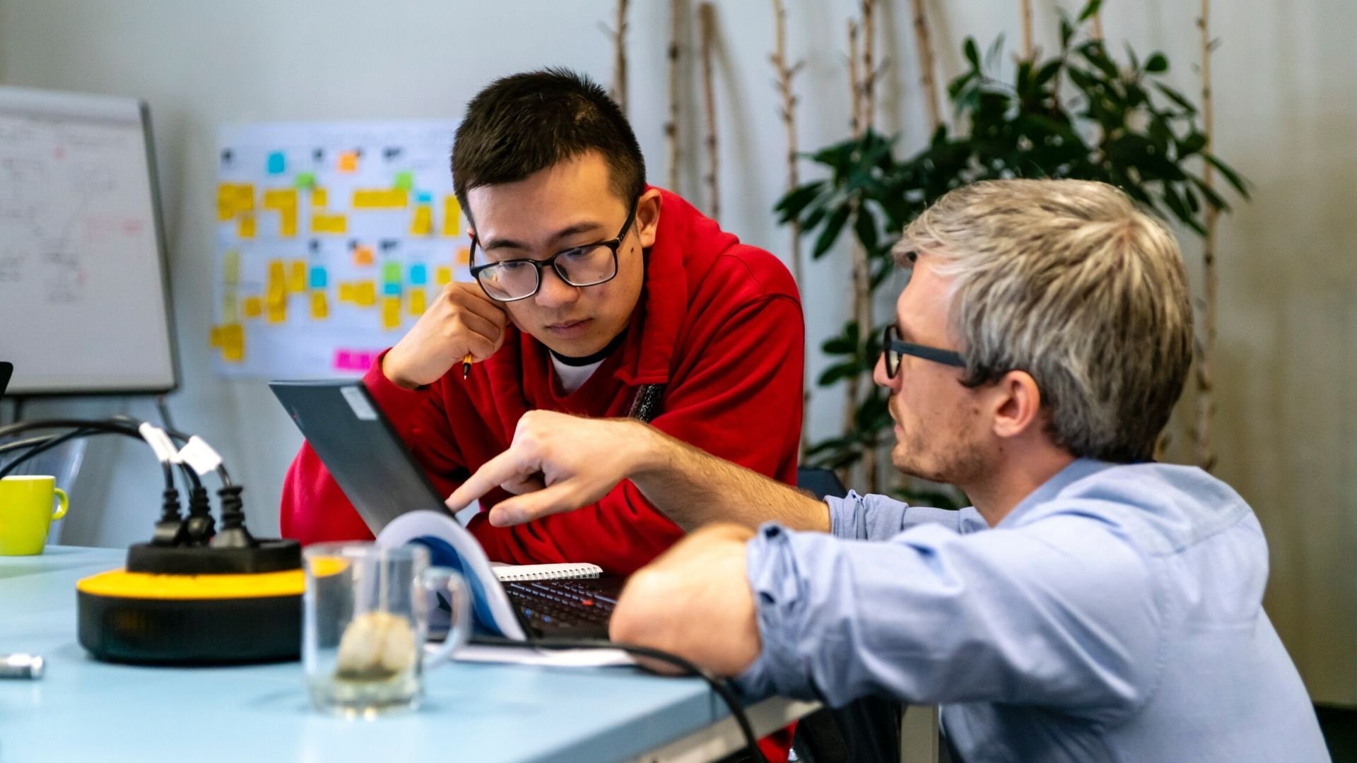 A manager explains a concept to a software engineer at an ASML Agile planning event A manager explains a concept to a software engineer at an ASML Agile planning event