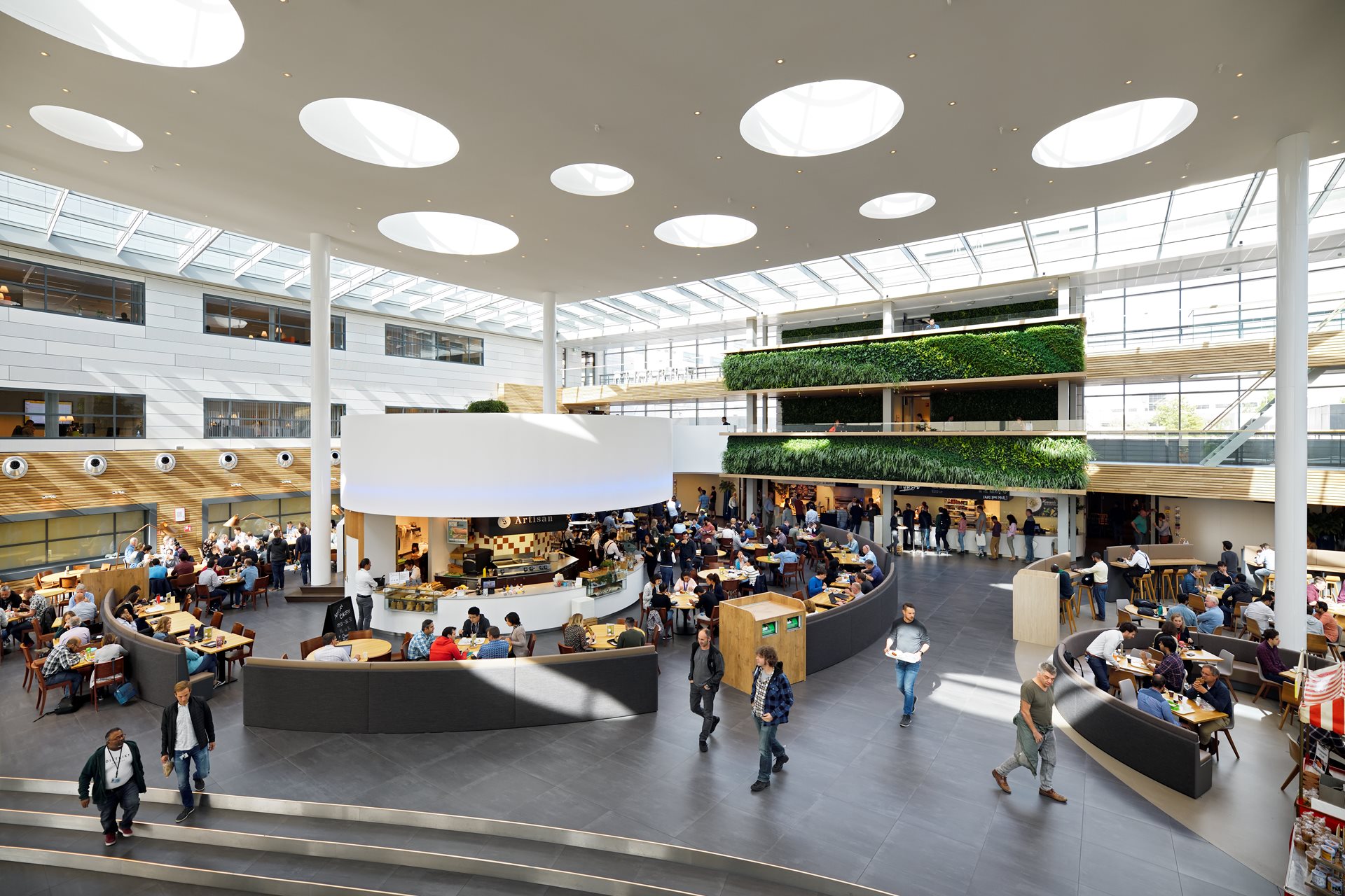 An overhead view of the cafeteria in the ASML headquarters, with people walking and sitting across the room. An overhead view of the cafeteria in the ASML headquarters, with people walking and sitting across the room.