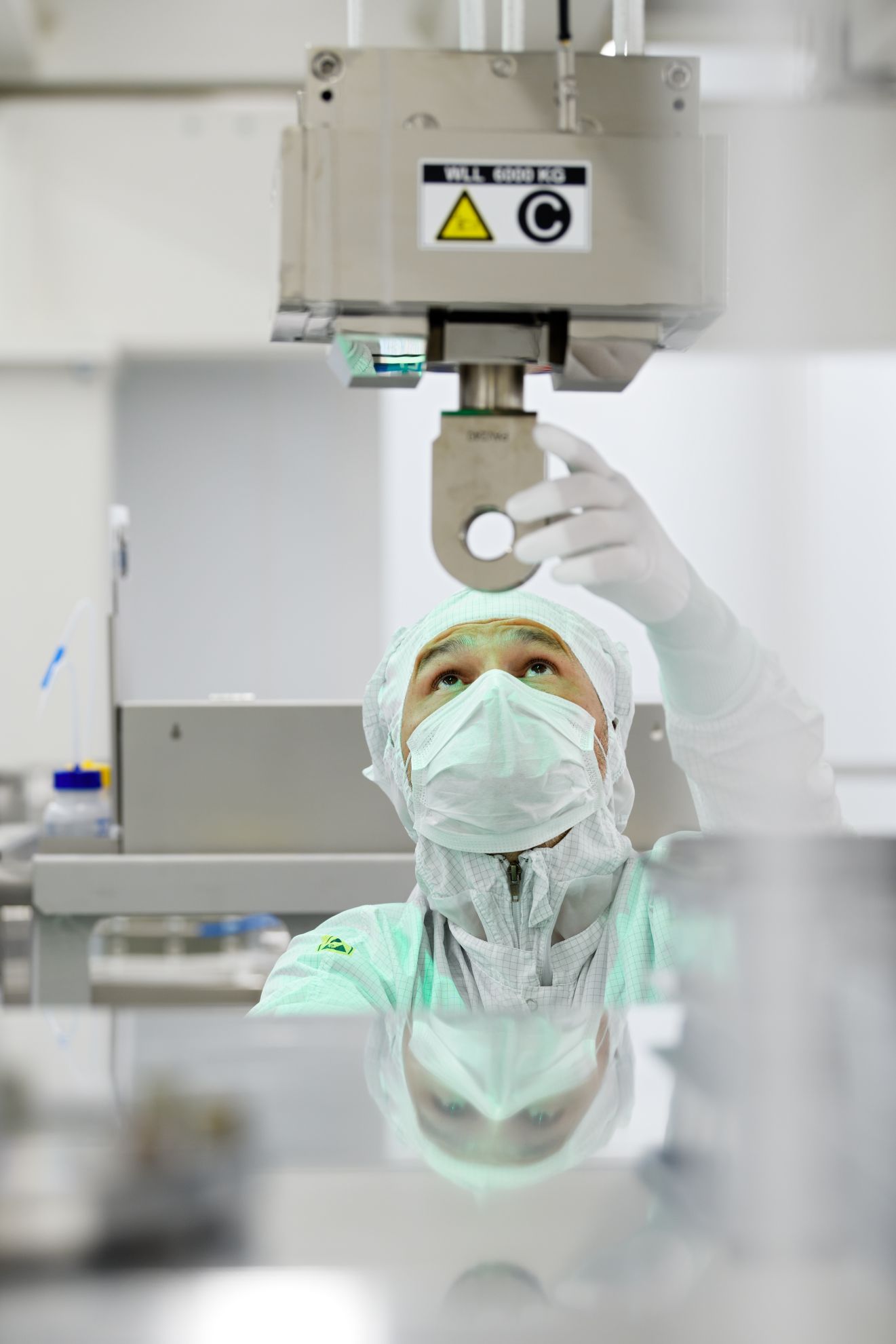 An ASML employee looks up into a machine in the cleanroom