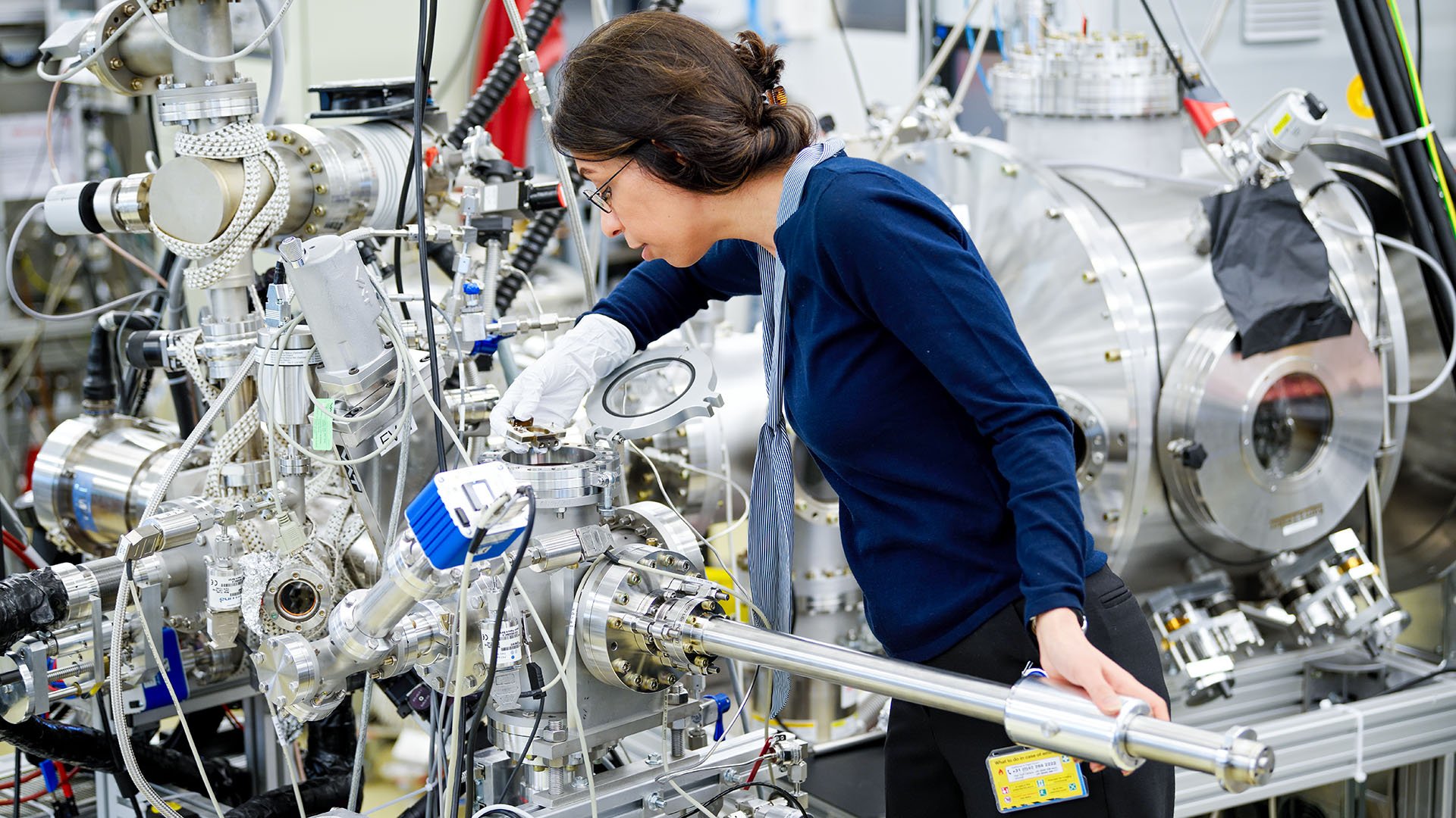 An ASML technician carefully adjusts complex equipment. An ASML technician carefully adjusts complex equipment.