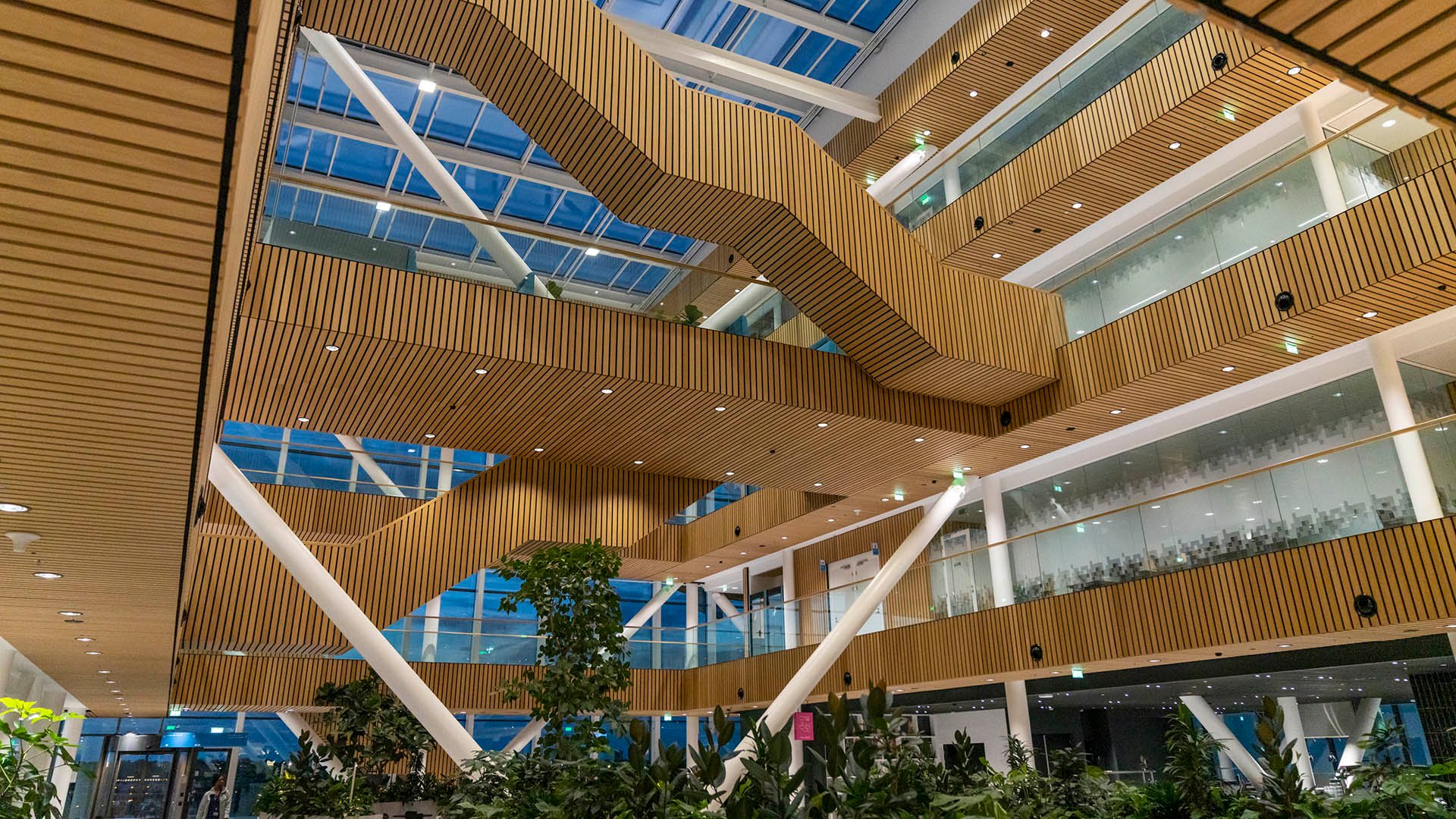 Open building interior with multiple levels and staircases under skylights