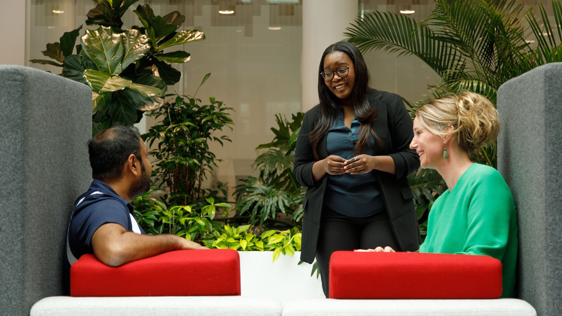 Person standing speaking to two people seated in a booth