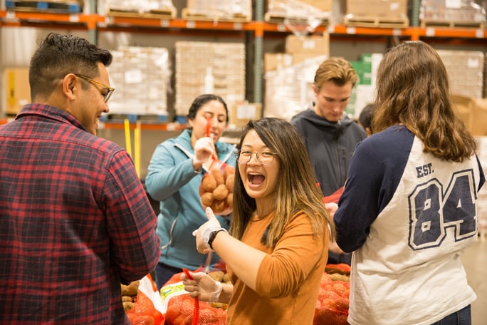 A group of plain-clothed ASML employees put together food parcels in a warehouse. A group of plain-clothed ASML employees put together food parcels in a warehouse.