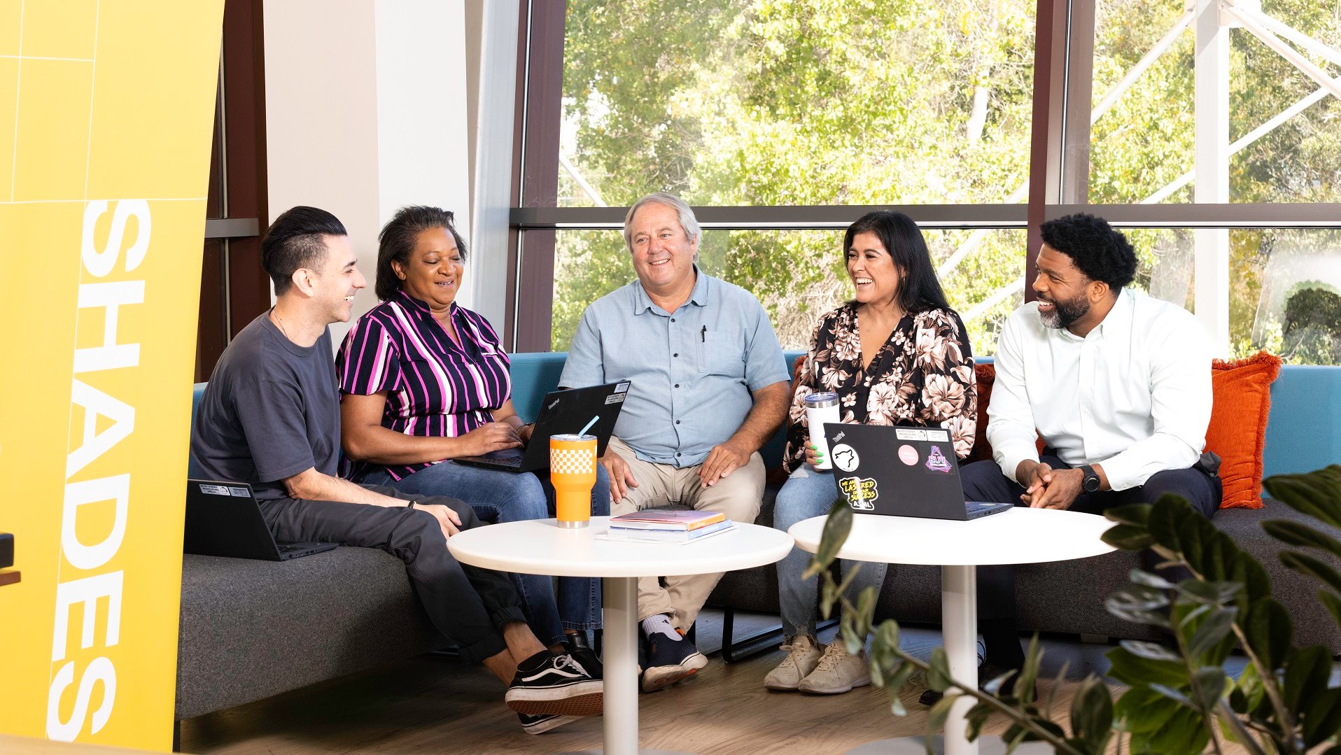 A diverse group of four people sit around a table in ASML Building 6 in Veldhoven, the Netherlands.