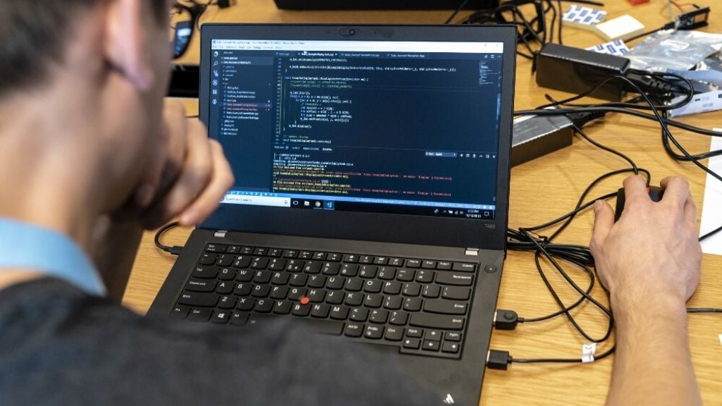 A software developer sits in front of a screen showing code at ASML's Digital Gold Hackathon in November 2018. A software developer sits in front of a screen showing code at ASML's Digital Gold Hackathon in November 2018.