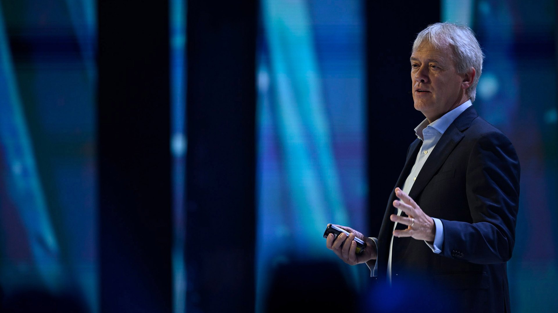 Blond man speaking on a stage