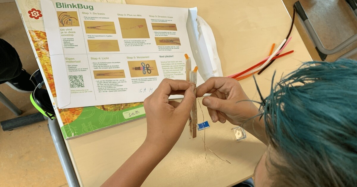 Student assembling BlinkBug STEM challenge with instructions Student assembling BlinkBug STEM challenge with instructions